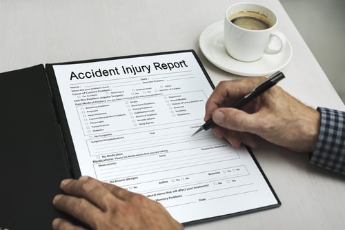 A person filling out an accident report after being injured.